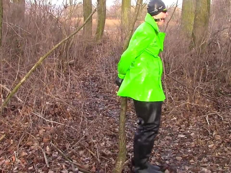 Handschellen in schwarzen waders und glänzendem Regenmantel